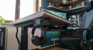 Dettaglio dei passacavi integrati e del gancio porta cuffie su una scrivania gaming moderna